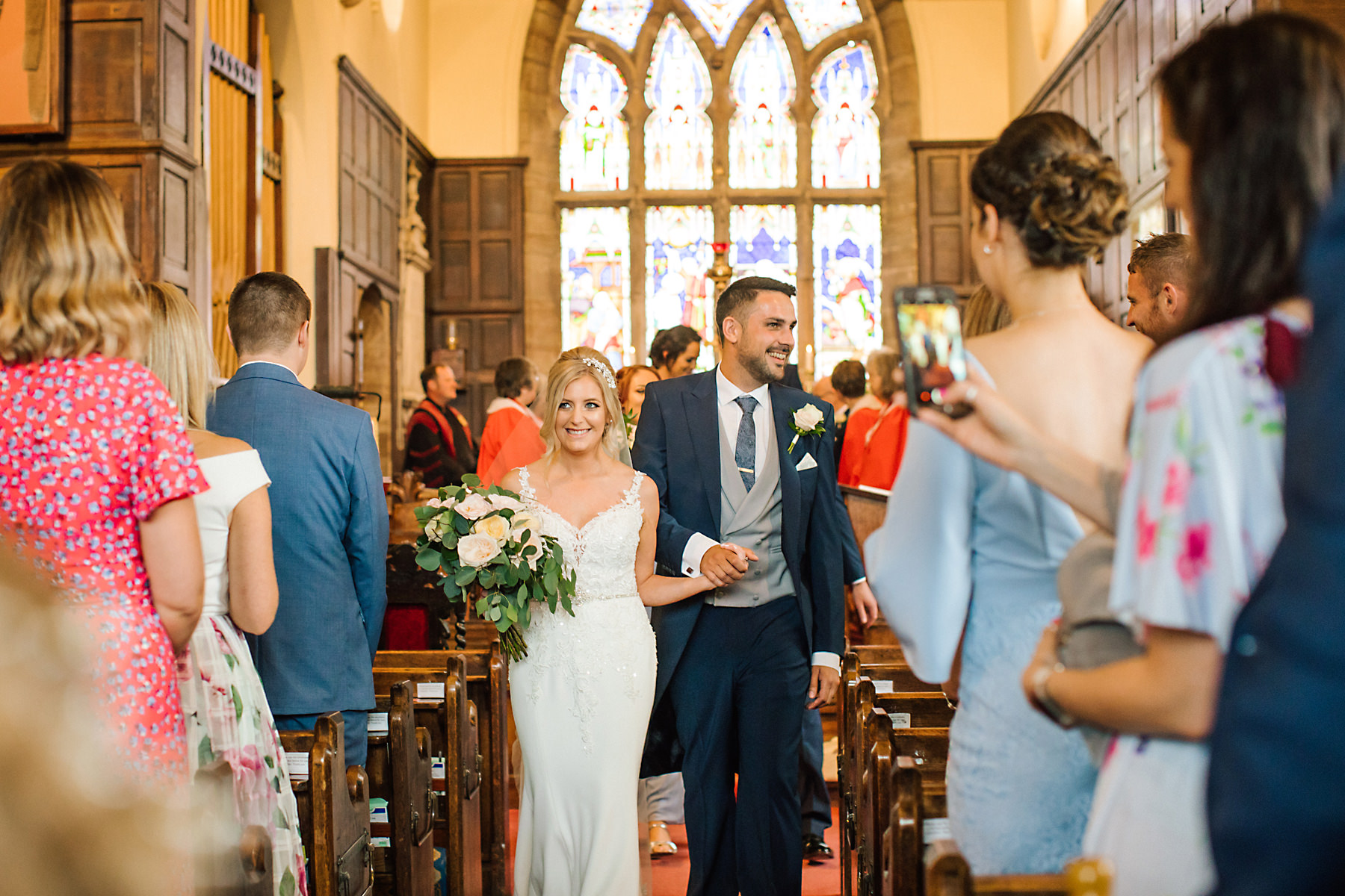 bride and groom walking down the church aisle