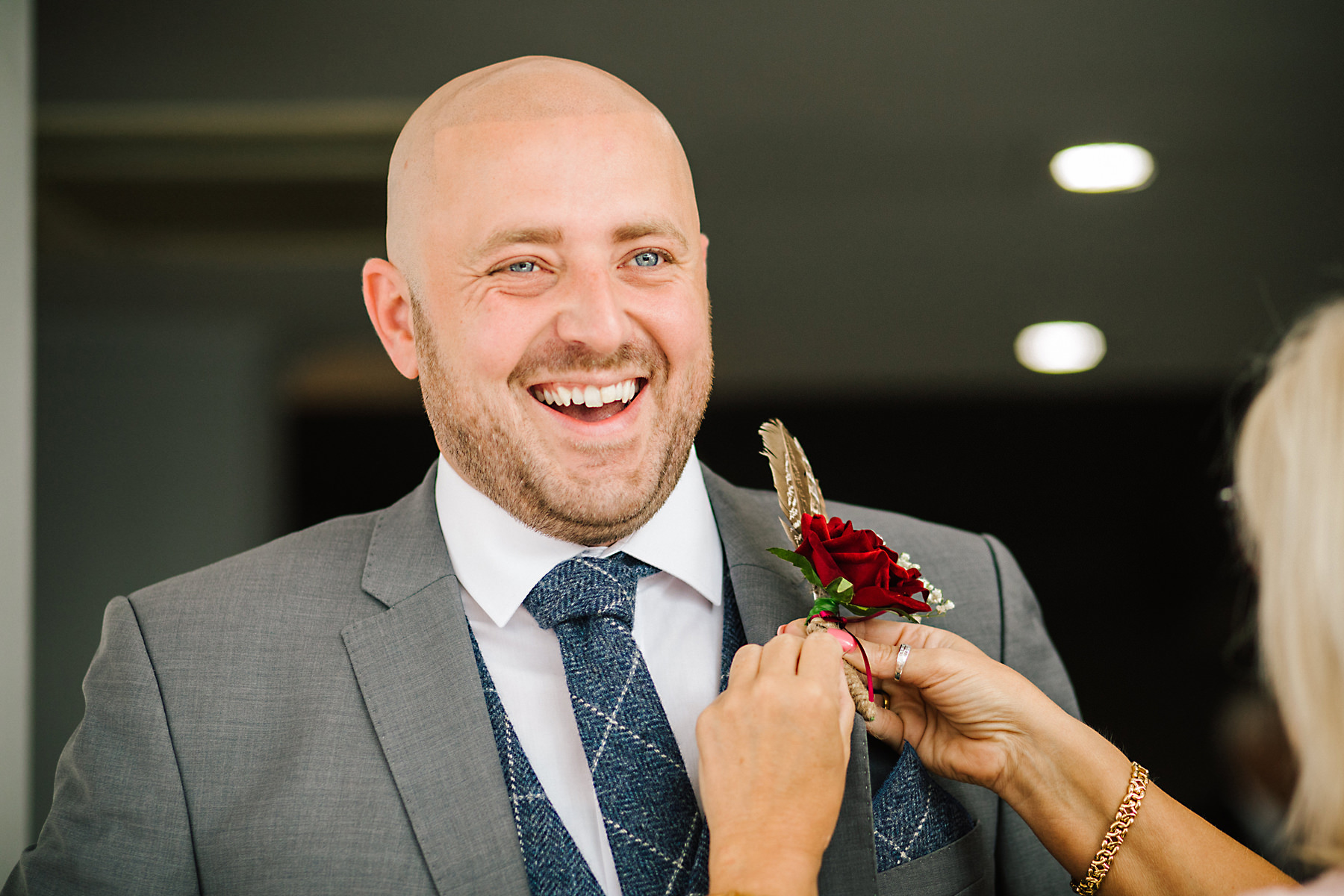 groom putting on buttonhole